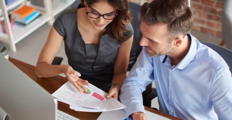 mpresários analisando gráficos financeiros com foco em contabilidade consultiva